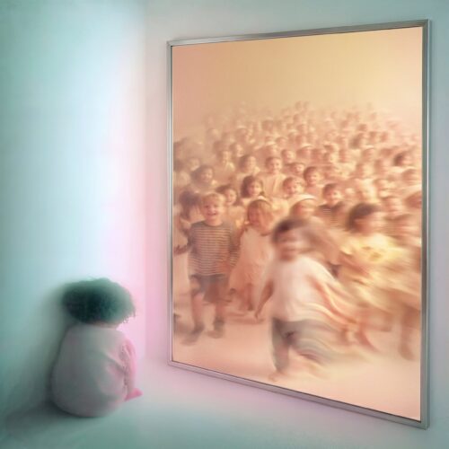 Un enfant assis seul dans le coin d'une pièce regarde un grand tableau lumineux.