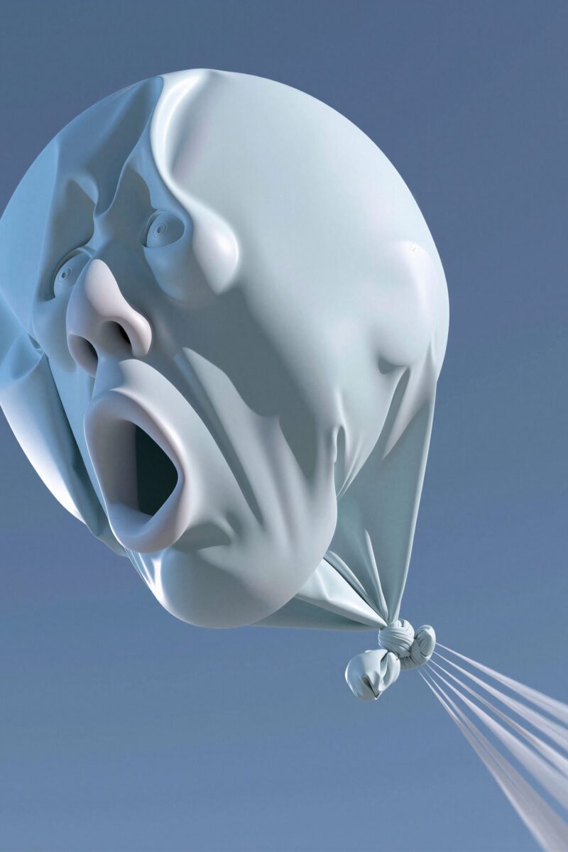 Ballon bleu clair gonflable sculpté en forme de visage humain hurlant dans le ciel.
