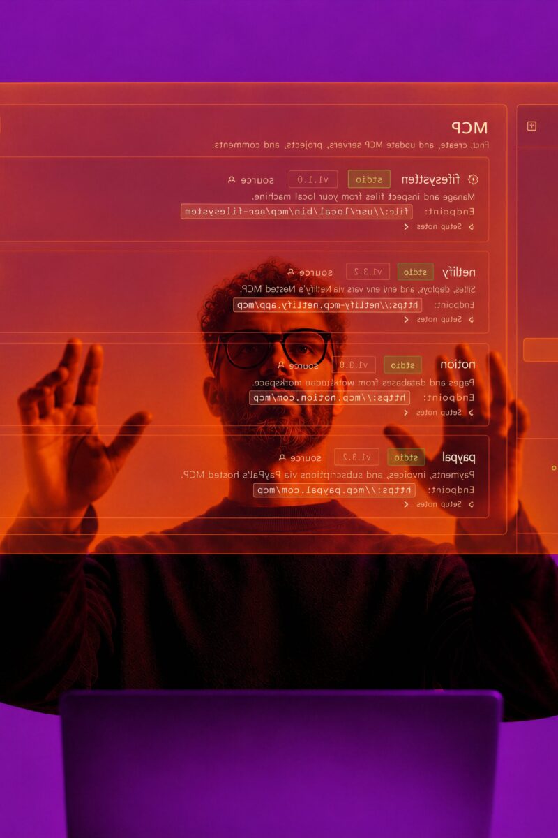 Un homme à lunettes interagit avec une interface numérique orange transparente sur fond violet.